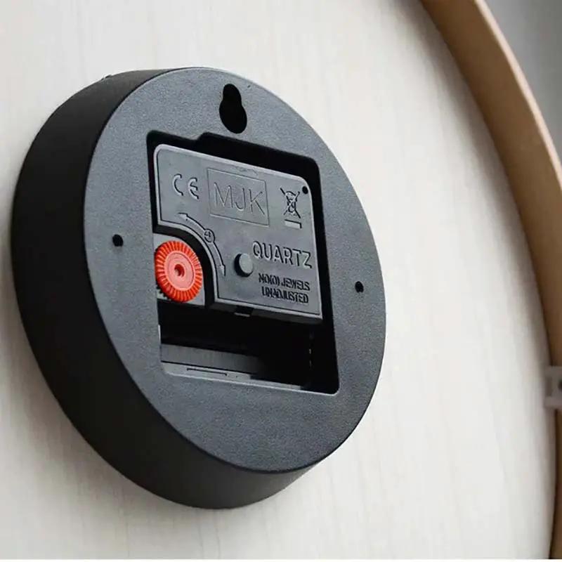 Nordic Wooden Wall Clock on a light wood wall; black circular case with battery compartment and red dial.