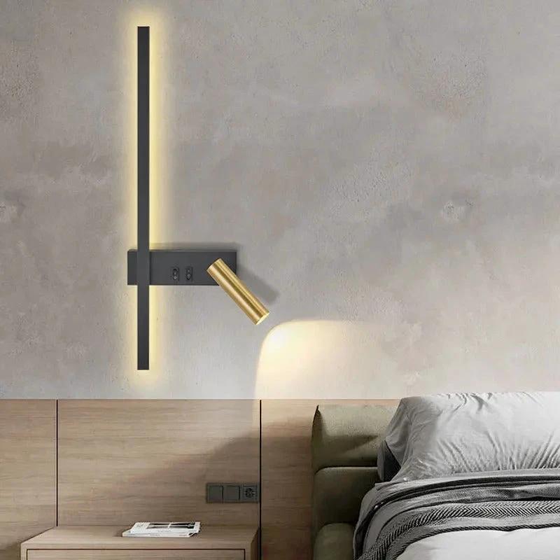 SVEA Swivel LED Wall Light, black metal wall plate with brass adjustable arm, mounted above bedside table in a bedroom.