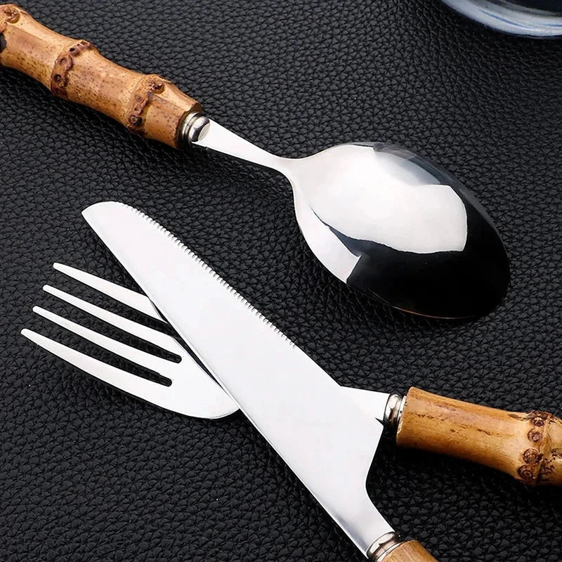 24-Piece Bamboo Handle Cutlery Set - Stainless Steel Flatware: bamboo-handled utensils on a dark textured surface (3 pieces shown)