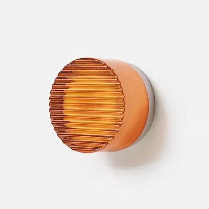 Wall light LYSEN minimalist metal sconce with amber ribbed glass on white wall.