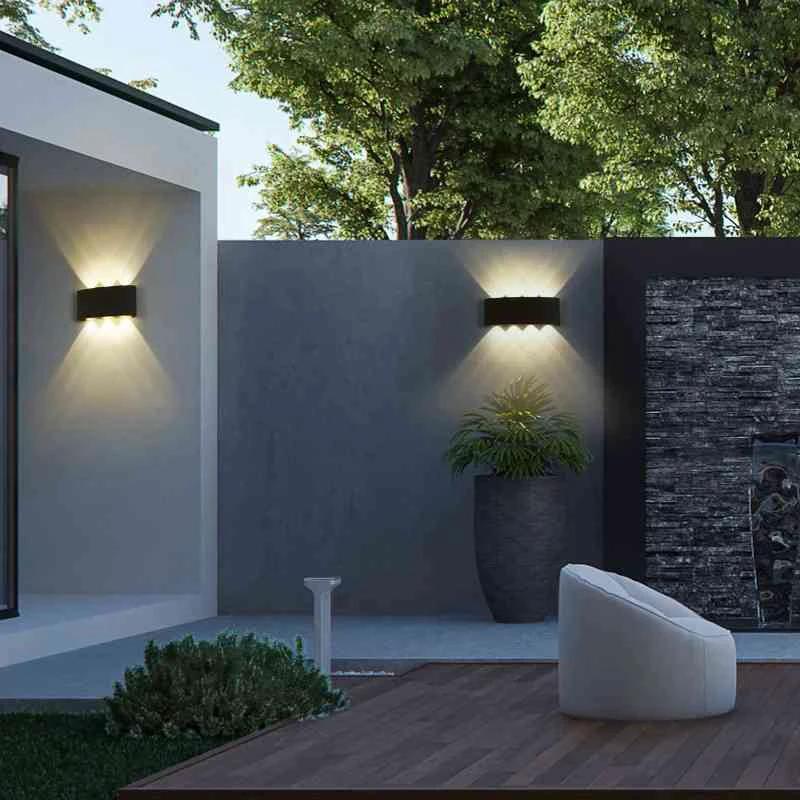 Modern Outdoor LED Wall Lamp, two black rectangular fixtures on exterior patio wall casting warm light.