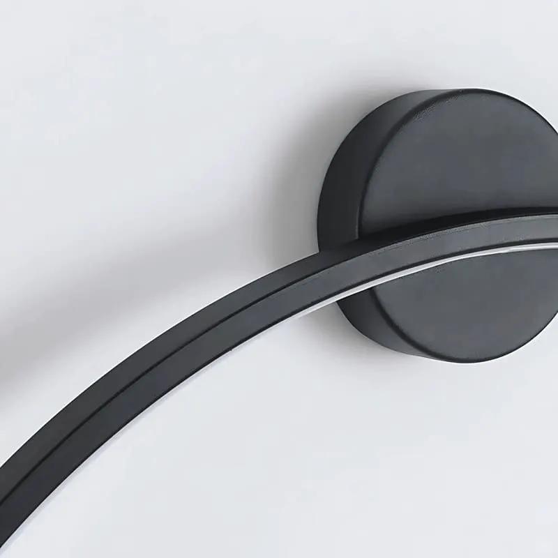 Black metal and acrylic LED ring wall lamp close-up showing slim illuminated frame and wall mounting base