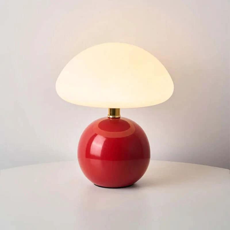 Modern ceramic table lamp with a red base and white shade on a neutral background