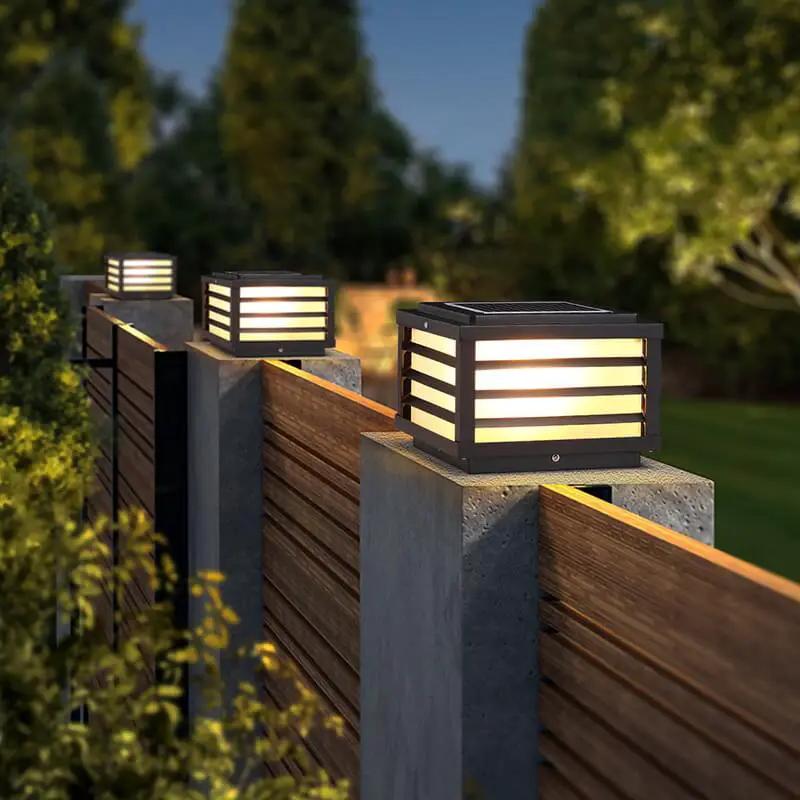 Modern solar post lights illuminating a Scandinavian-style fence and garden pathway with warm LED outdoor lighting